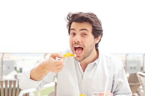 Junger Mann isst Nachos — Stockfoto