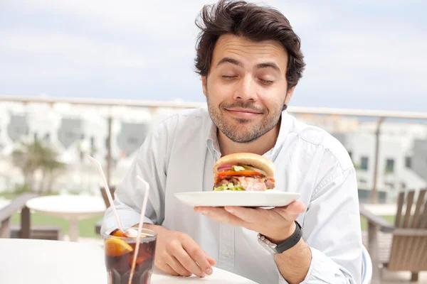 Jovem comendo um hambúrguer — Fotografia de Stock