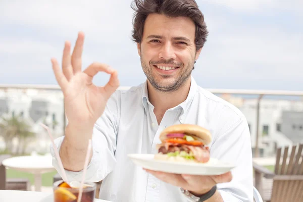 Jovem comendo um hambúrguer — Fotografia de Stock