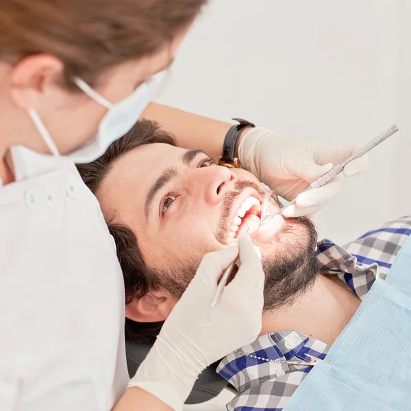 Jovem feliz homem e mulher em um exame odontológico no dentista — Fotografia de Stock