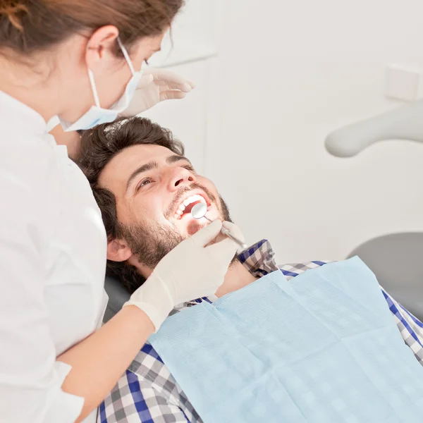 Jovem feliz homem e mulher em um exame odontológico no dentista — Fotografia de Stock