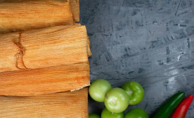 Mexican cuisine, meat tamales accompanied by garlic, chili and tomato