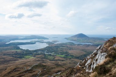 Tepenin tepesinden görünen dağ manzarası. Bulutlu gökyüzü. İrlanda, Eiurope