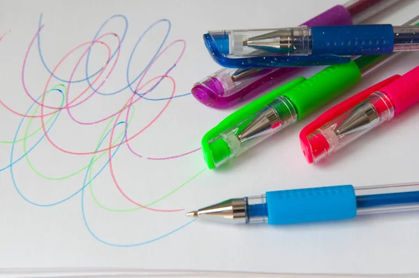 Set of new colorful pens for the school. Drawings on a white paper. Scholar materials