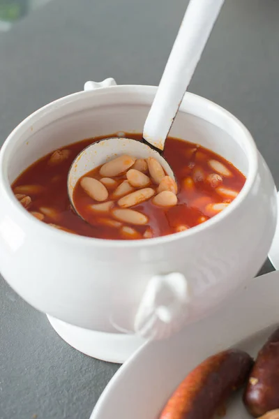 Ev yapımı masal servis eden kepçenin kapağını kapatın. Geleneksel yoldaşla birlikte kâse ve meze, kanlı sosis ve sucuklu. Asturias, İspanya. Avrupa