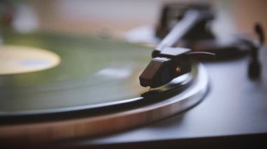 İğne vinil plaktan yükseliyor. Vinil plak kaydı durdu. Vinil plak dönüyor. İğne vinil plakla çalınıyor. Eski pikap. Eski