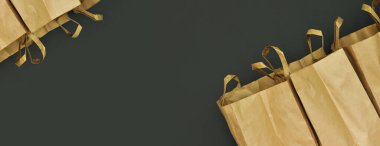 Sürdürülebilir kağıt alışveriş torbaları. Boş kahverengi çantalar, koyu arka planda izole edilmiş. Metin için boş alan. Market konsepti, yemek teslimatı, ulaşım çözümleri