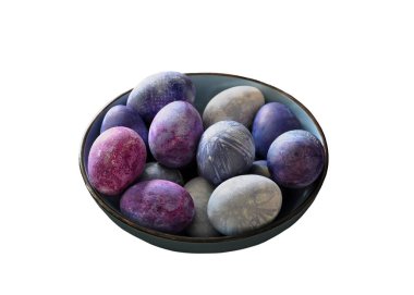 Kasede renkli yumurtalar. Çilekli yumurta boyası. Kırılganlık, yemek sanatı, Paskalya konsepti. Beyaz arka planda izole edilmiş. Gerçekçi yatay görüntü. Mavimsi, mor palet