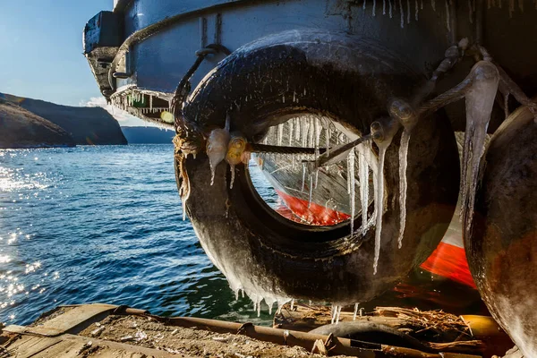 바이칼호가 보이는 곳에서 겨울에 고드름이 있는 나룻배의 아래쪽 스톡 사진