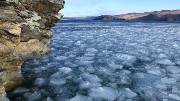 Ghiaccio galleggiante nel lago Baikal vicino alla riva rocciosa al momento del congelamento — Video Stock