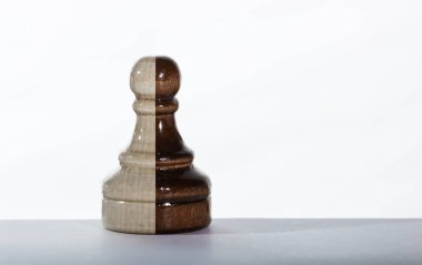 Siyah ve beyaz renkli satranç piyonu masada tek başına duruyor.
