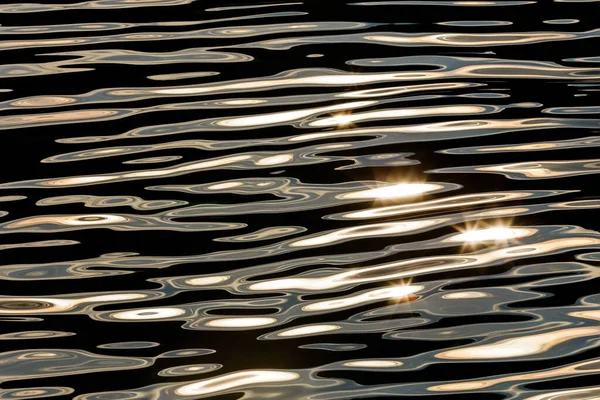 Fotografía abstracta en contraste de las aguas superficiales del mar o el océano al atardecer con pequeñas estrellas — Foto de Stock