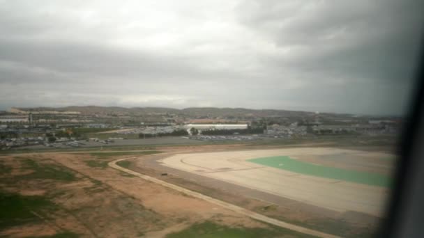 El avión aterriza en el aeropuerto. Nublado. Vista desde la ventana. — Vídeos de Stock