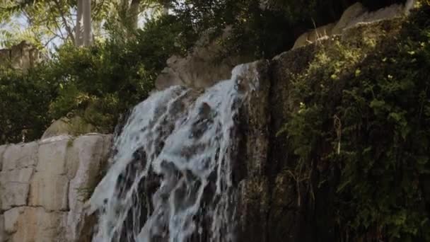 Ett litet starkt vattenfall i skuggan, nära klipporna. — Stockvideo