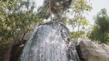 Çerçevenin ortasında küçük, güçlü bir şelale. Alt görünüm.