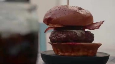 Peynirli ve pastırmalı lezzetli bir burgerin yakın çekimi. Arkaplan Restoranı