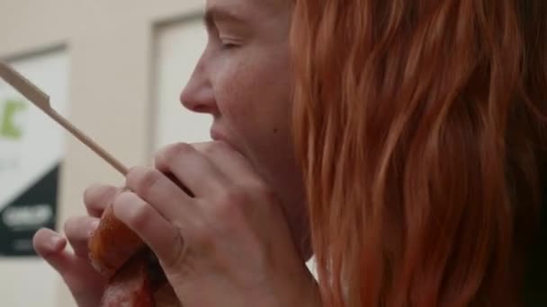 Gyönyörű nő vörös hajú eszik burger étteremben — Stock videók