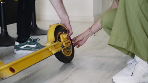 Elektrikli scooterların tamiri için atölye çalışması. Usta motosikletin tekerleğini kontrol eder.. — Stok video