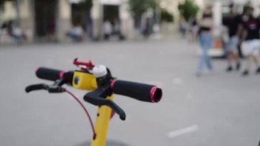 Bir kadın şehirde scooter 'a biniyor. Elektrikli scooter ile gidip gelmek