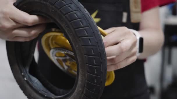 Młoda piękna kobieta mechanik pracuje w warsztacie naprawczym, naprawianie hulajnoga kick. — Wideo stockowe