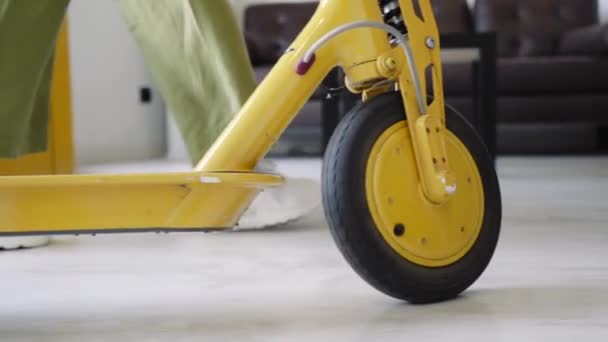 Una chica con un scooter entra en un taller para reparar scooters eléctricos. — Vídeos de Stock