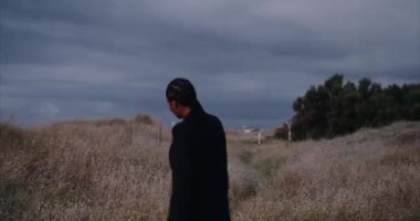 Plajda çantalı siyah seksi kız, geceleri sahada yürüyor.