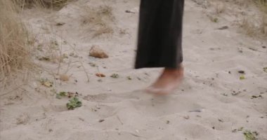 Siyah seksi kız sahilde yürüyor. Gün doğumu. Kızların bacakları.