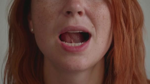 Привлекательная девушка с рыжими волосами, шевелит языком. — стоковое видео