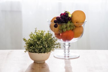 Ahşap masa üzerinde cam kase meyve