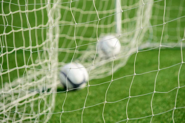 Fußballnetz mit unscharfen Bällen im Hintergrund — Stockfoto
