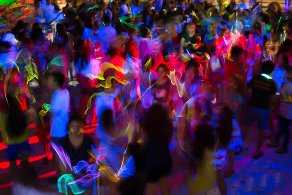 Pessoas dançando em um brilho na festa escura — Fotografia de Stock