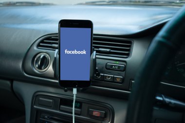 Onun ekranda sosyal medya ile genel bir otomobilin Kontrol Paneli'nde monte Smartphone.