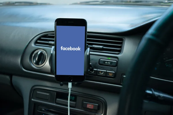 Smartphone mounted on a generic car's dashboard with social media on its screen. — Stock Photo, Image