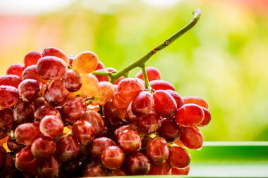 Tepsilerde tohumsuz kırmızı üzüm buketi döşedi..