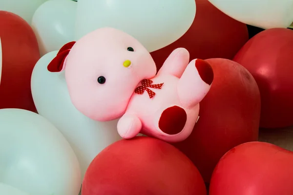 Rosa Puppe Liegt Auf Einem Haufen Roter Und Weißer Luftballons — Stockfoto