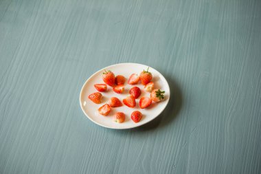 Çilekler ikiye bölünür ve tabağa çeşitli parçalar yerleştirilir..