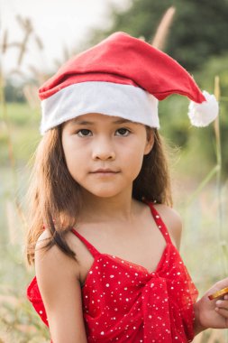 Kırmızı bir Noel gösterisinde bir kız ve mutlu bir şekilde gülüyor..