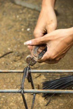 Tamirci çelikle bağlanmış bir tel kullanıyor..
