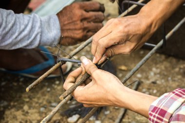 Tamirci çelikle bağlanmış bir tel kullanıyor..
