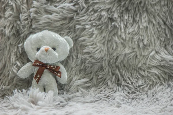 Ein Kleiner Weißer Teddybär Liegt Auf Einem Stück Wolle — Stockfoto