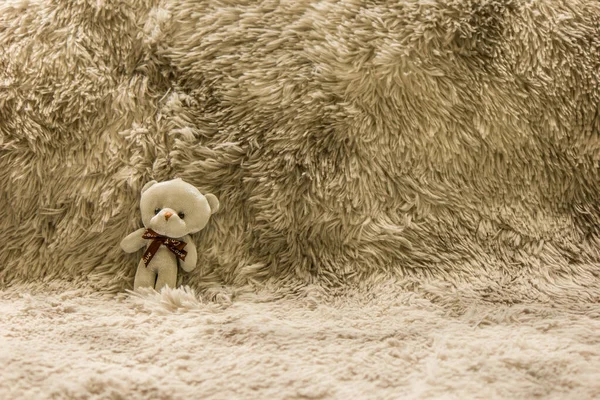 Ein Kleiner Weißer Teddybär Liegt Auf Einem Stück Wolle — Stockfoto