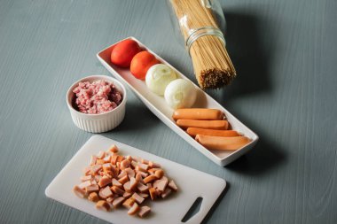 Aile için soğan, domates, füme sosis ve domuz eti gibi malzemelerle spagetti yap..