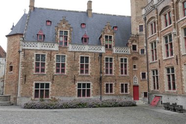 Bruges, Flanders, Belçika 10-18-2025 tarihsel Gruuthusemuseum binasının avlu manzarası. Birden fazla kat, pencere ve kayrak çatı var..