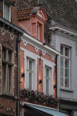 Bruges, Flanders, Belçika 10. 18. 2025 Eski tuğla binalar dizisi. Şehir ortamında eşsiz mimari tasarımlar, pencereler ve çiçek sergileniyor..