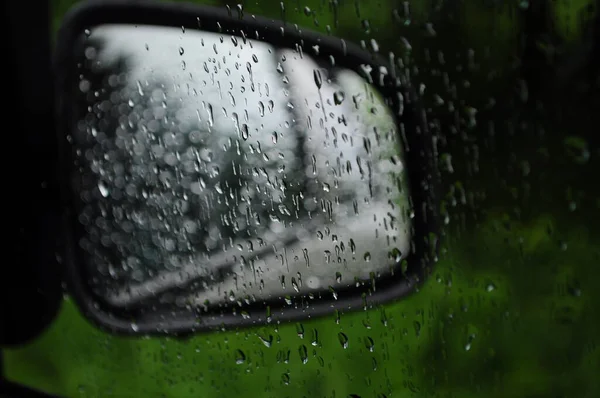 raindrops on car glass against the background of car mirror