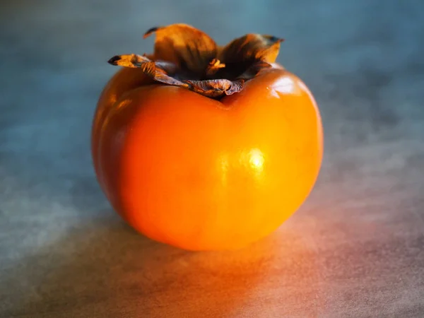 Oranje Persimmon Een Grijze Achtergrond — Stockfoto