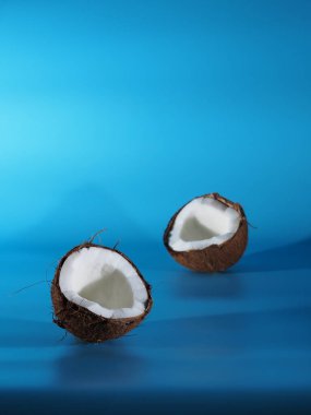 Mavi arka planda iki yarım hindistan cevizi