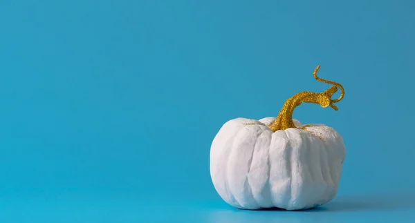 Biała Dynia Złotym Błyszczącym Łodygą Niebieskim Tle Koncepcja Minimalizmu Halloween — Zdjęcie stockowe