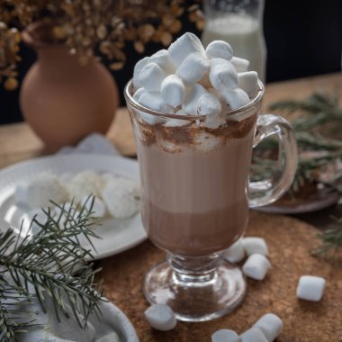 Tahta bir masanın üzerinde lokum olan bir fincan sıcak çikolata. Bir fincan sıcak içecek. Kış içkisi. Sıcaklık. Sıcak kış sabahı. 