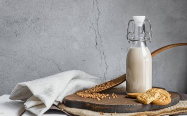 Vejetaryen karabuğday sütü. Alternatif süt. Sağlıklı vejetaryen yiyecek ve içecek konsepti. Uzayı kopyala Bir şişe karabuğday sütü. Tahta kaşık ve karabuğday. Glütensiz yemek. .